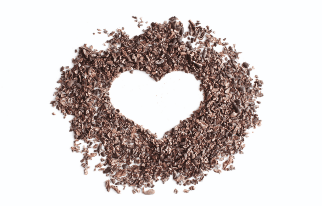 Cacao nibs shaped as a heart. Ingredients for hot cocoa.