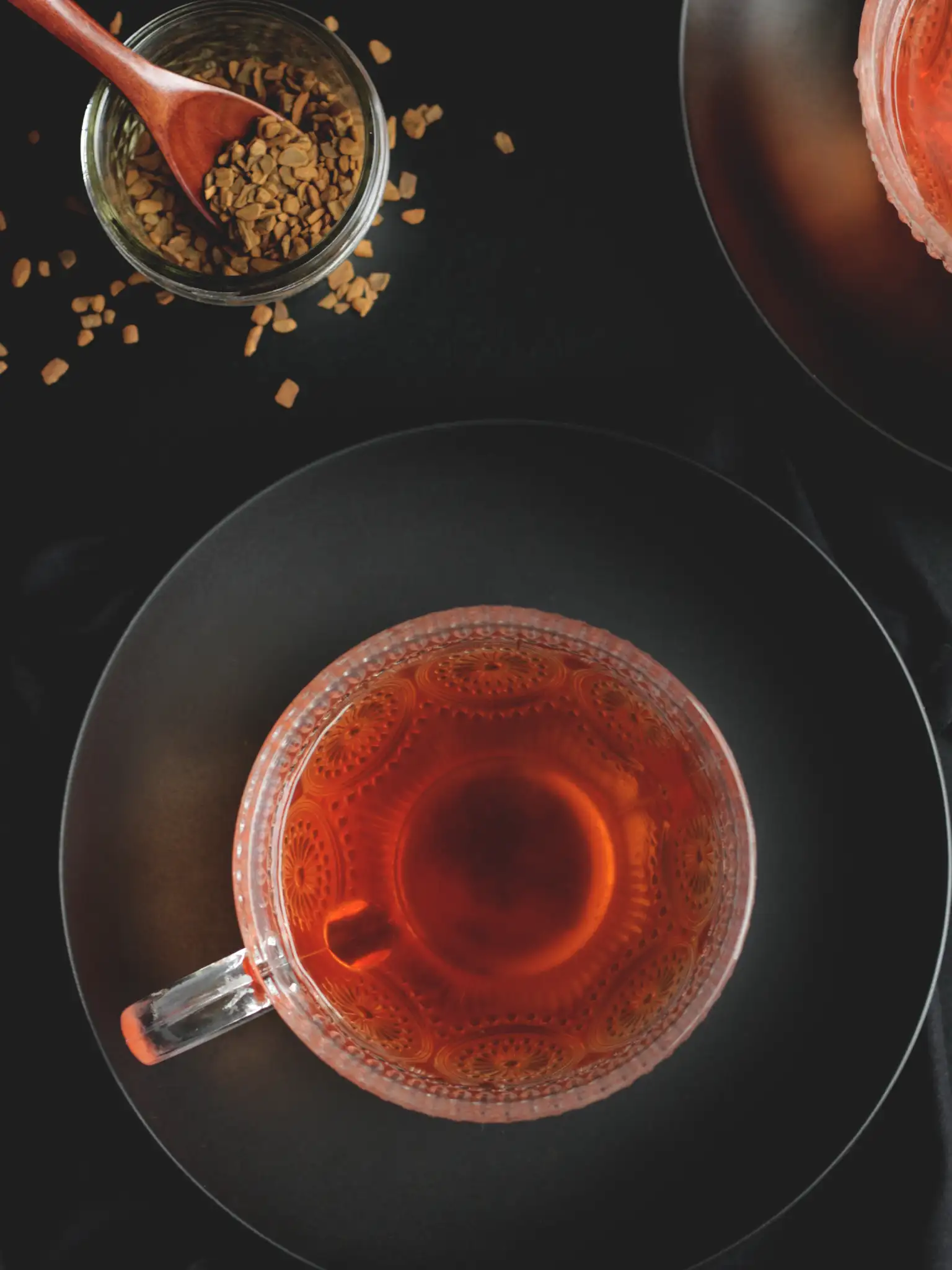 cinnamon ginger herbal tea in a glass mug with cinnamon chips scattered