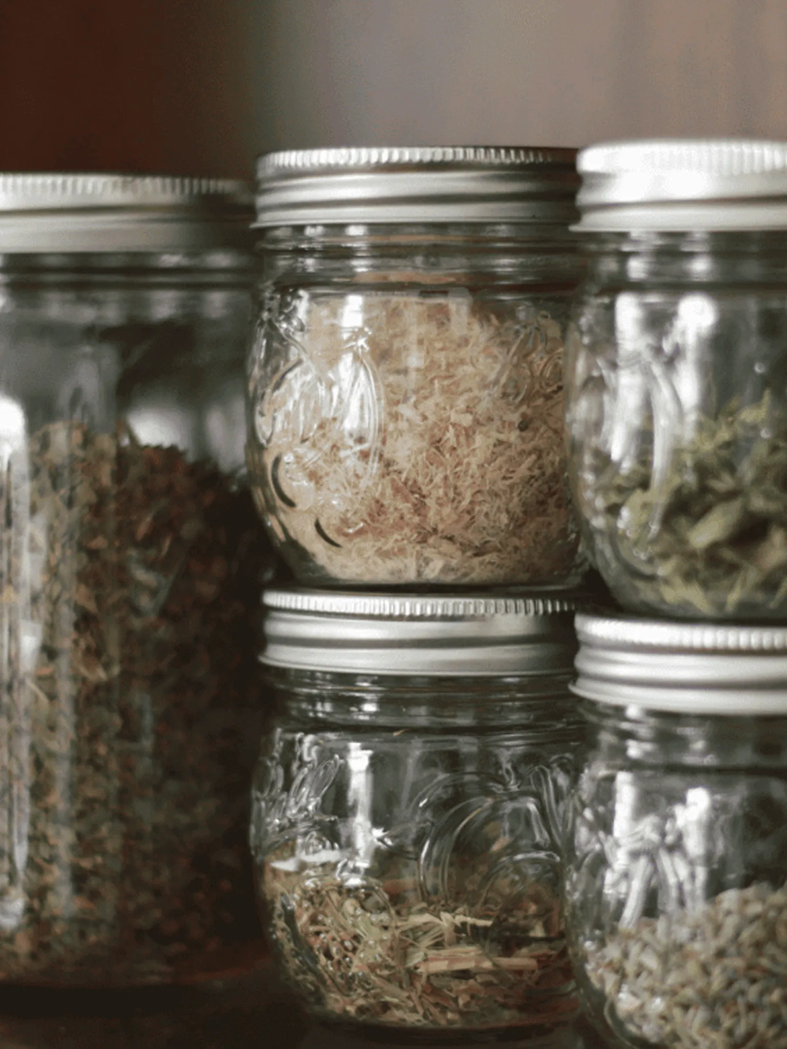 Mason jars filled with a variety of dried herbs. Herby Gardens apothecary.